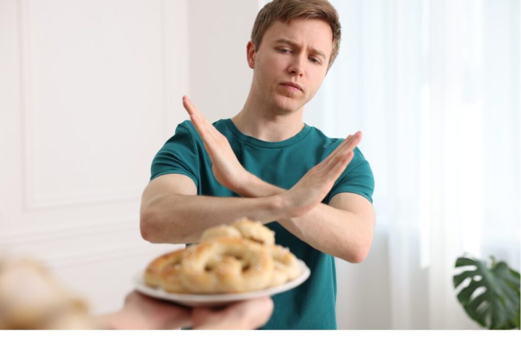 ダイエットのためお菓子を食べるのを躊躇している男性